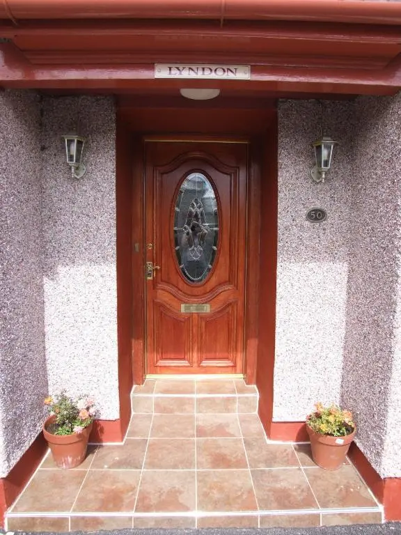 a wooden door with two potted plants in front of it at Lyndon Guest House in Inverness