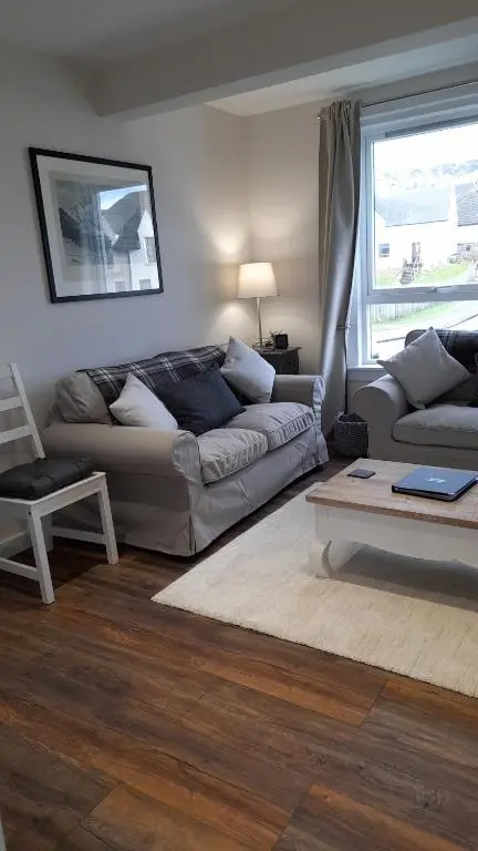 a living room with a couch and a table at The Dookit - Aviemore Town House in Aviemore