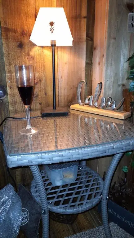 a glass of wine and a lamp on a table at The Dookit - Aviemore Town House in Aviemore