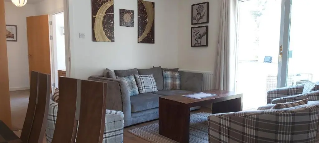 a living room with a couch and a table at Loch Ness Abbey Cottages in Fort Augustus