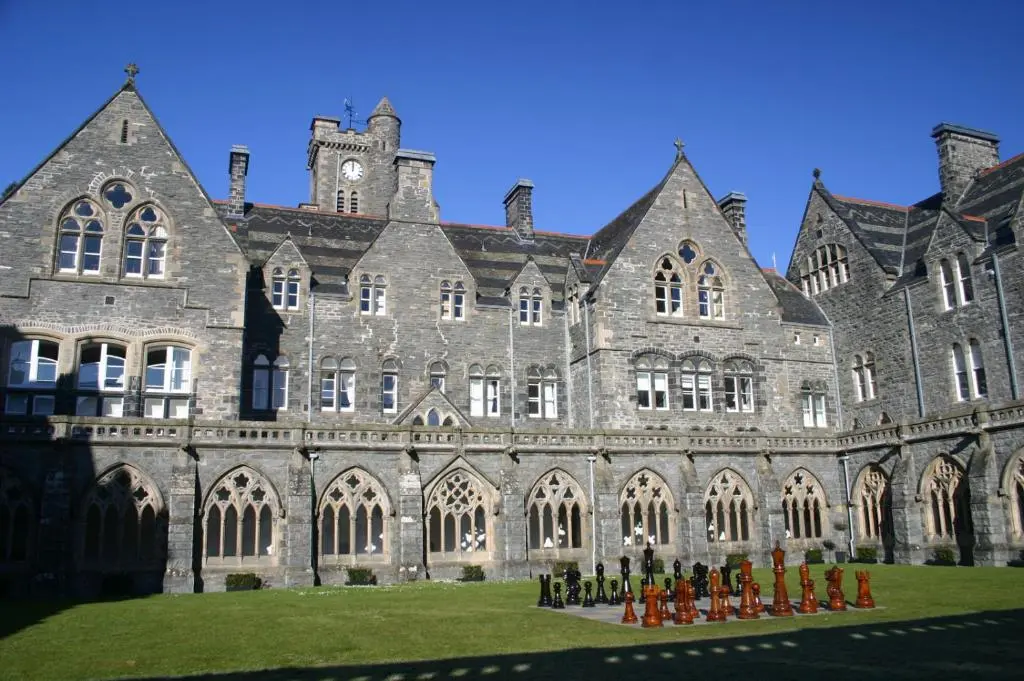 a large building with people standing in front of it at Loch Ness Abbey Cottages in Fort Augustus