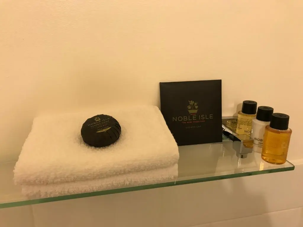 a glass shelf with towels and a box on it at Tullich House in Keith
