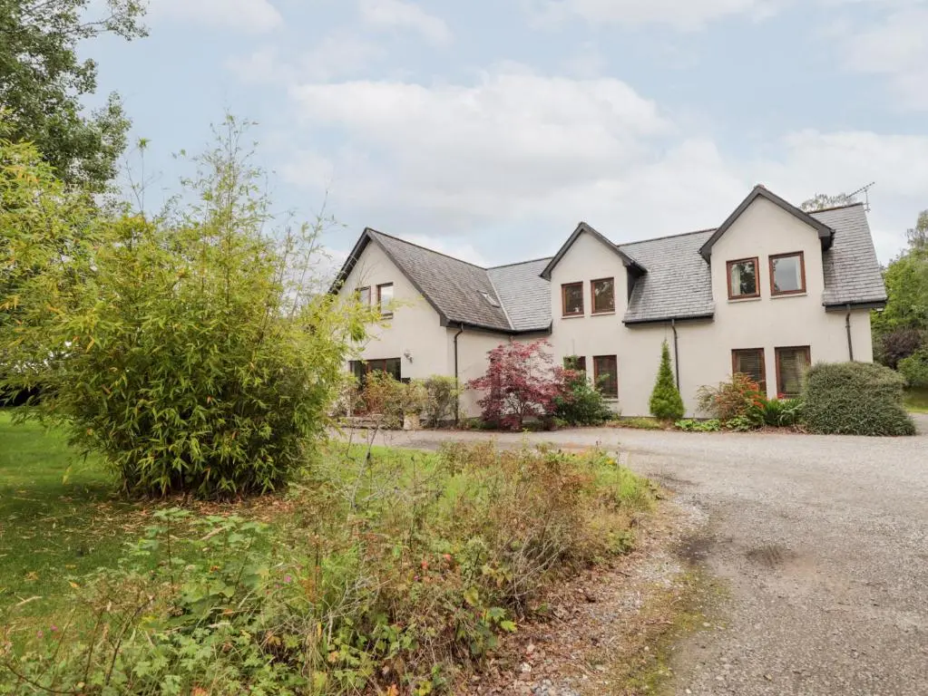 a large white house with a driveway at An Torr in Newtonmore