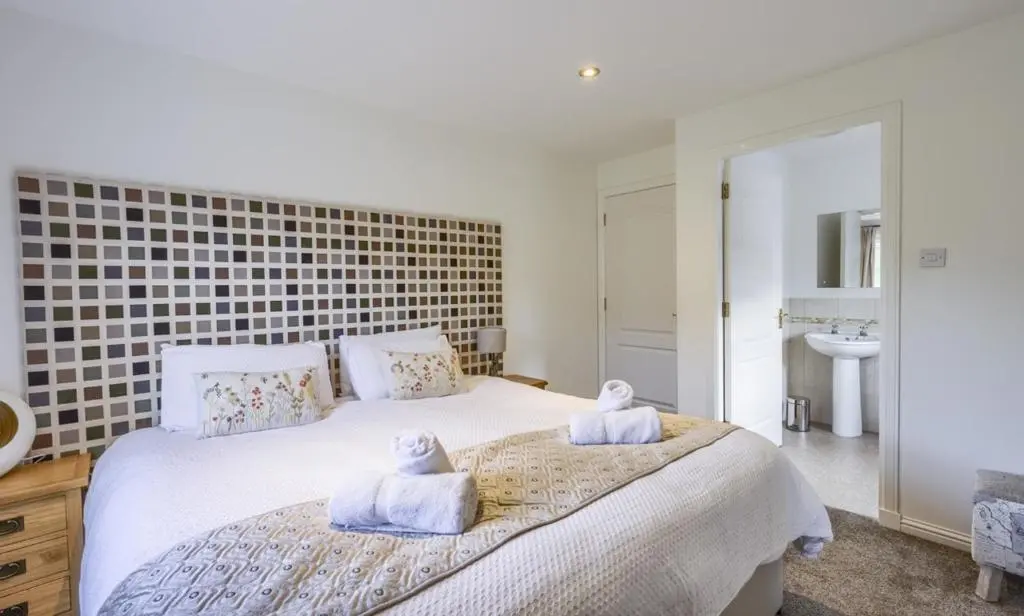 a bedroom with a large bed with towels on it at Apartment 20 Inchmarlo in Banchory