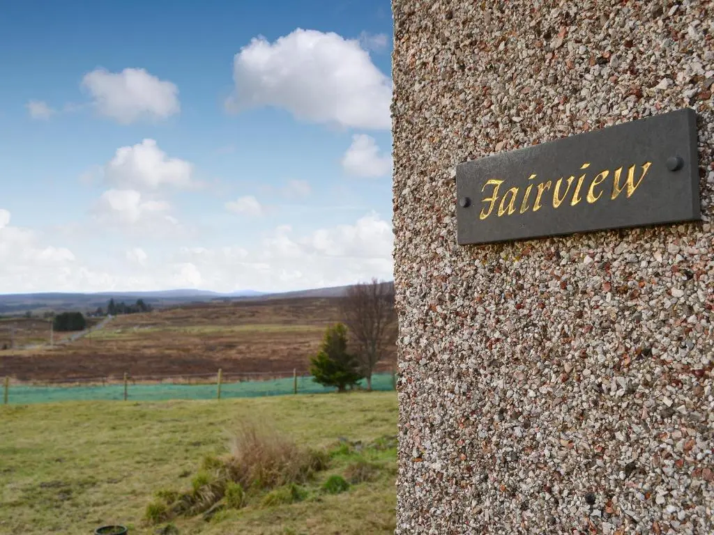 a sign on the side of a stone wall at Fair View in Lairg