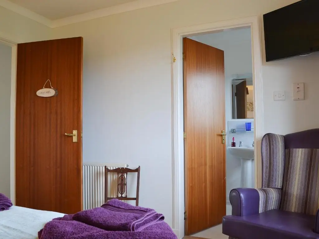 a bedroom with a purple blanket on a bed at Fair View in Lairg