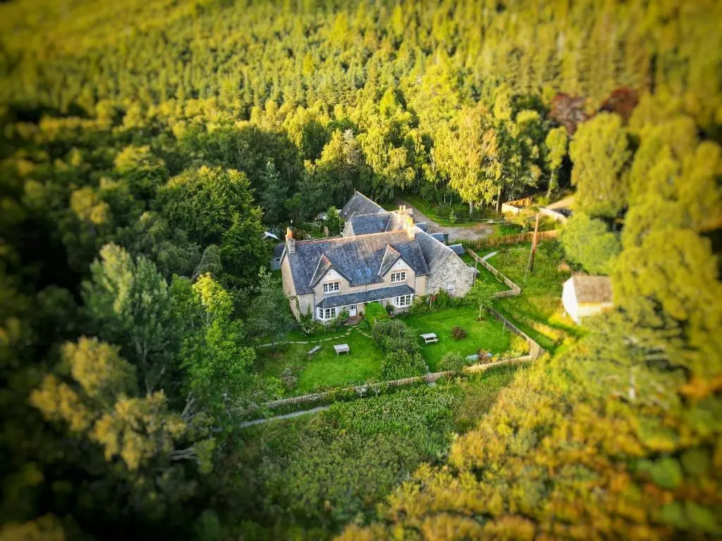 an aerial view of a large house in the forest at Stable Cottage, CrannachCottages in Garve