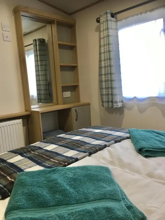 a bedroom with two beds and a window at Bynack Lodge in Boat of Garten