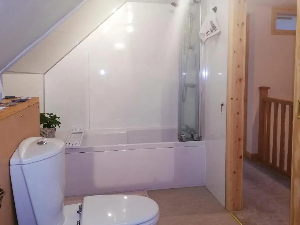 a bathroom with a toilet and a bath tub at St Brighs in Dingwall