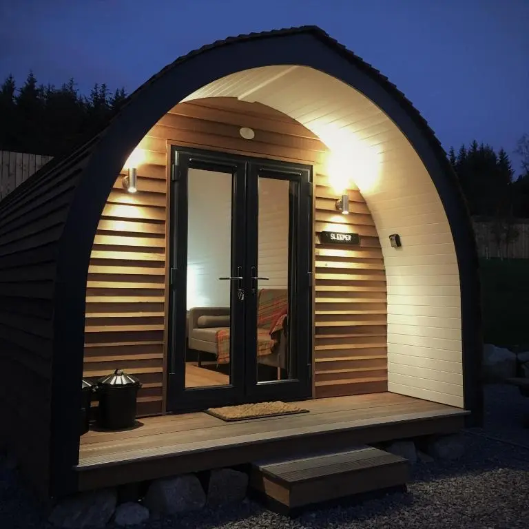 a large arched doorway to a sauna with a window at Tomatin Glamping Pods in Inverness