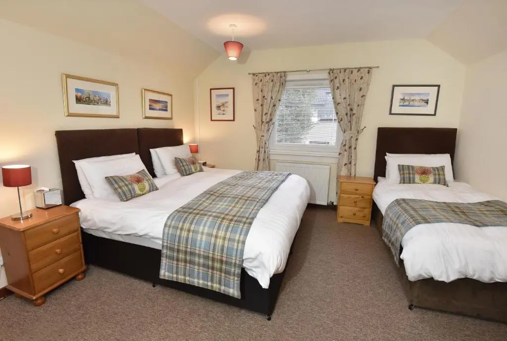 a bedroom with two beds and a window at Acer Glen B&B in Inverness