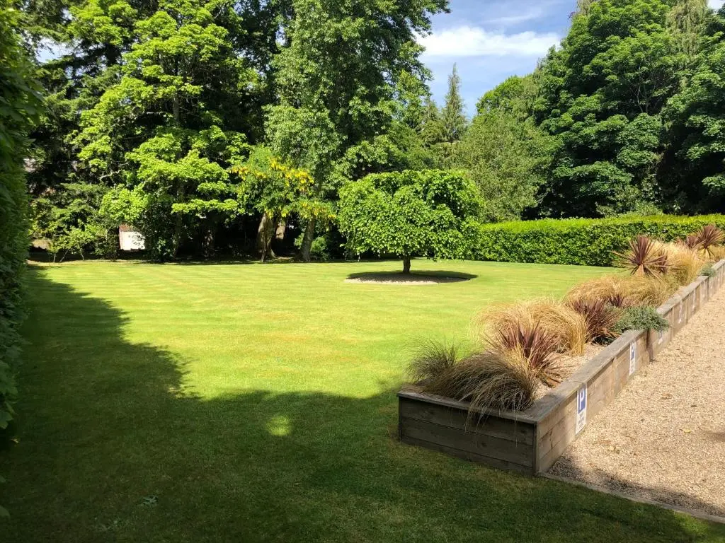 a garden with a park with a tree and grass at Rossal House Apartments in Inverness