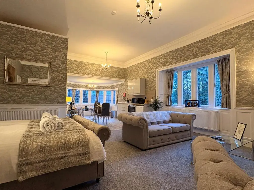 a bedroom with a bed and a living room at Rossal House Apartments in Inverness