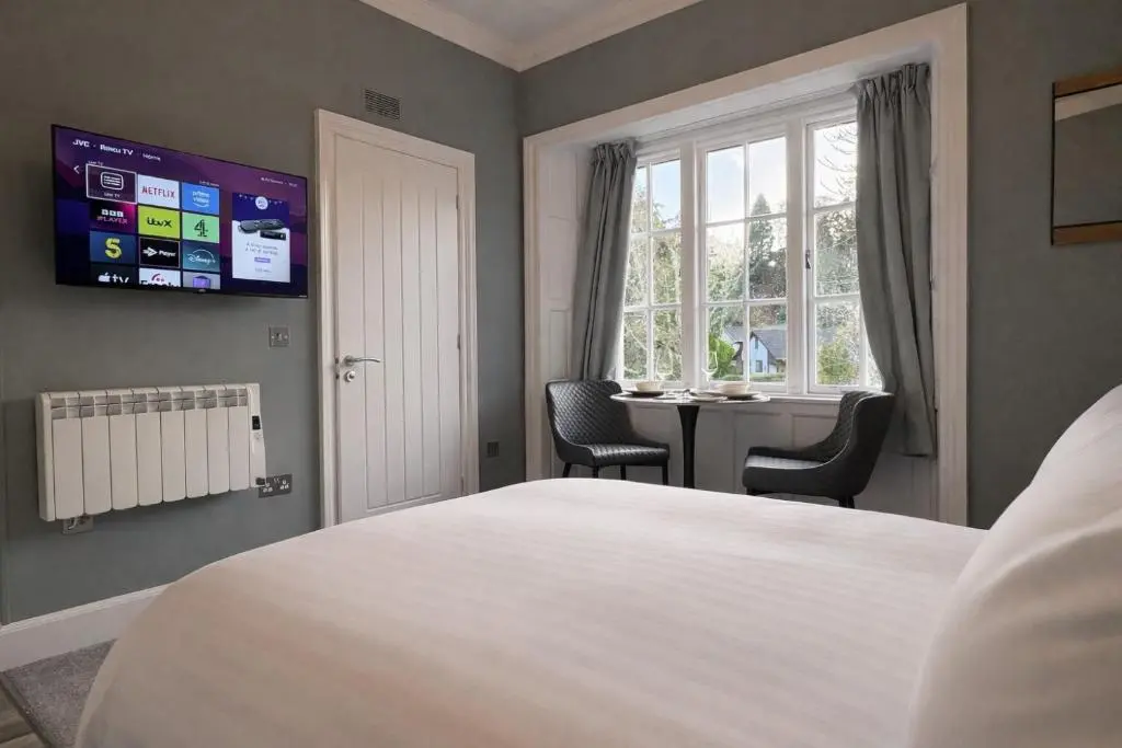 a bedroom with a bed and a desk and a window at Rossal House Apartments in Inverness
