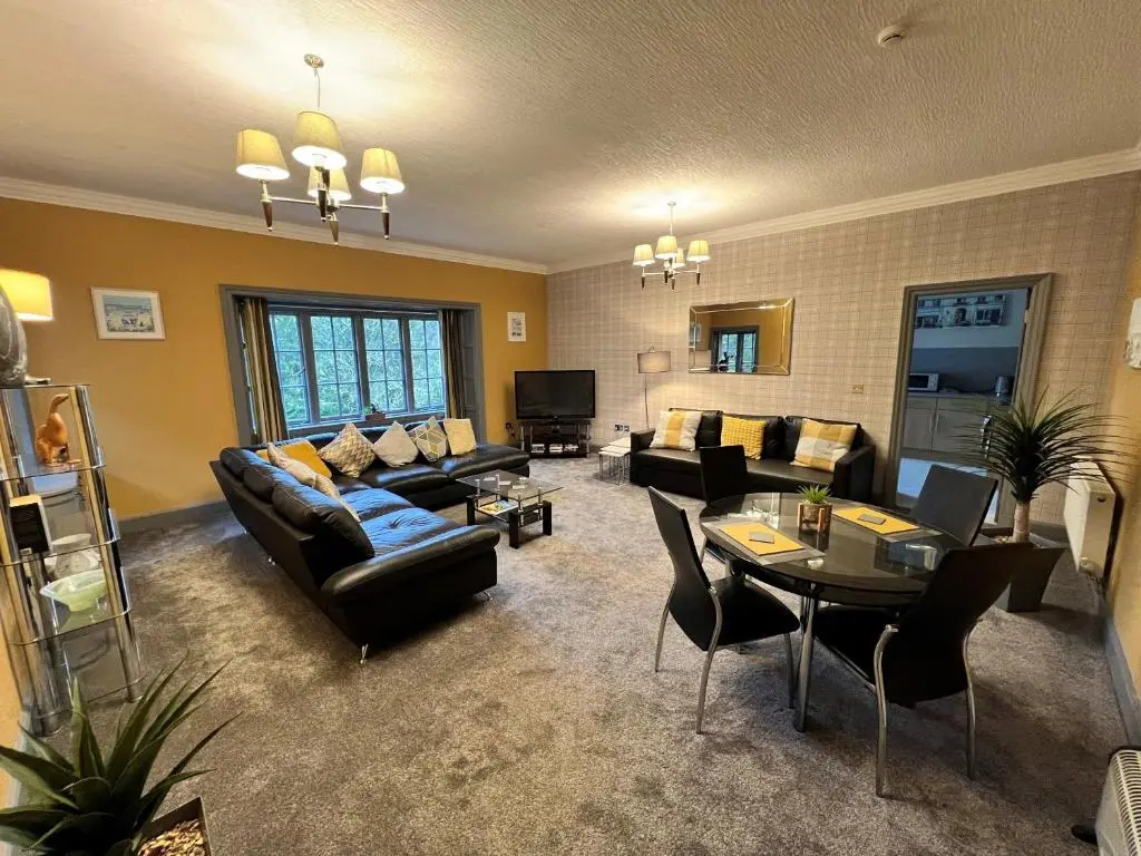 a living room with couches and chairs and a table at Rossal House Apartments in Inverness