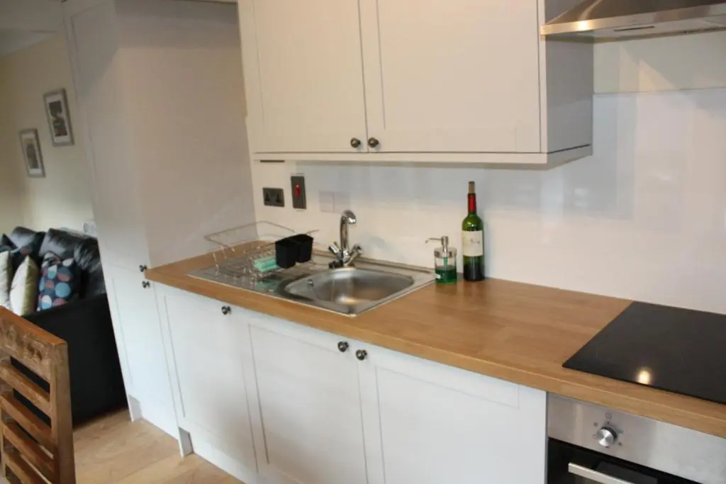 a kitchen with a sink and a bottle of wine at Loch Ness Balcony Apartment in Drumnadrochit