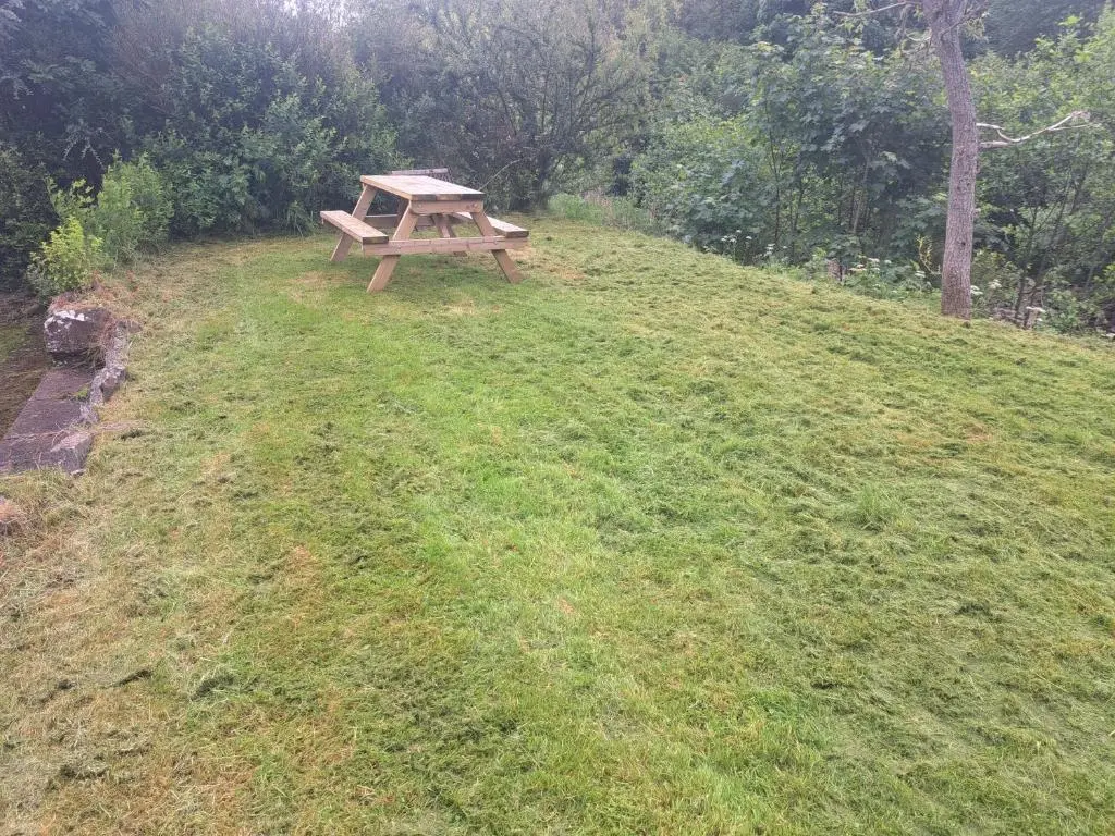 a picnic table sitting on top of a grass field at Loch Ness Balcony Apartment in Drumnadrochit