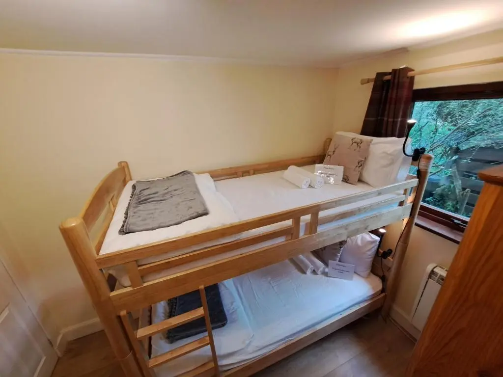 a bunk bed in a room with a window at Loch Ness Balcony Apartment in Drumnadrochit