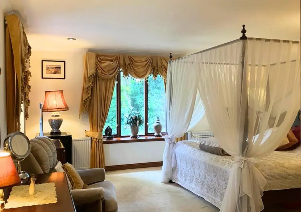 a bedroom with a canopy bed and a window at Stunning 7 Bedroom Bungalow Alford Aberdeenshire in Alford