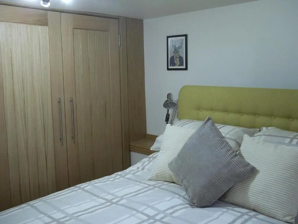 a bedroom with a bed with white sheets and pillows at The Wee Thistle Loch Ness in Drumnadrochit