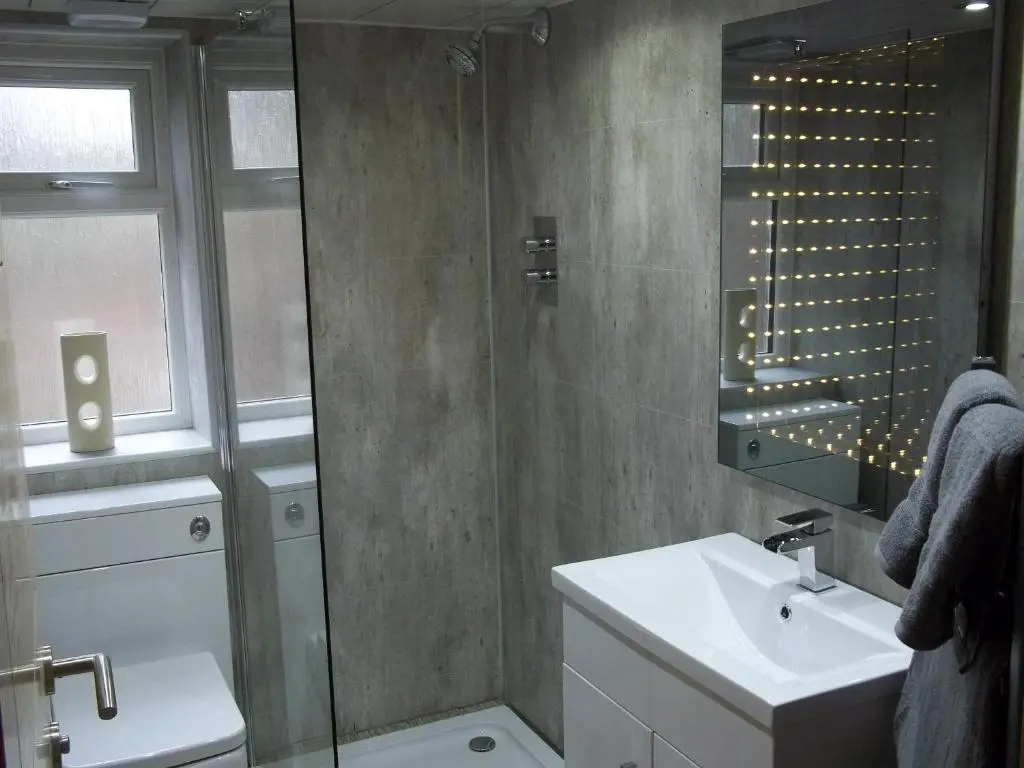 a bathroom with a sink and a glass shower at The Wee Thistle Loch Ness in Drumnadrochit