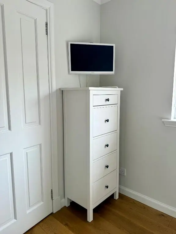 a white dresser with a tv on top of it at The Salmon Hut in Aberlour