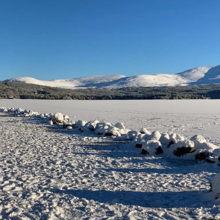 a row of snow covered rocks in the middle of a lake at The Balavoulin - Pub with Rooms in Aviemore