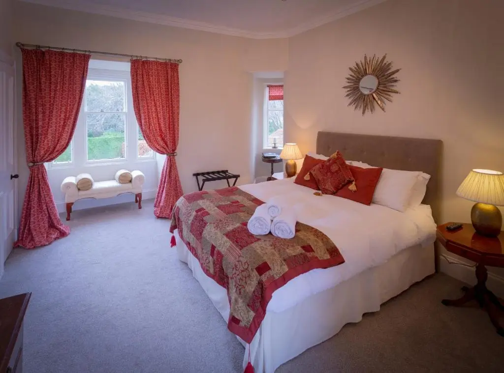a bedroom with a bed with two white towels on it at Craigellachie Lodge in Craigellachie