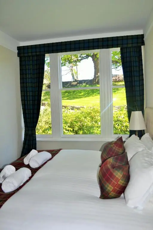 a bedroom with a bed with a large window at Craigellachie Lodge in Craigellachie