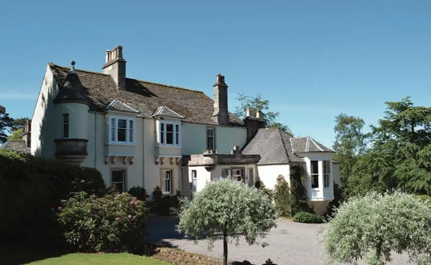 a large white house with a driveway at Craigellachie Lodge in Craigellachie