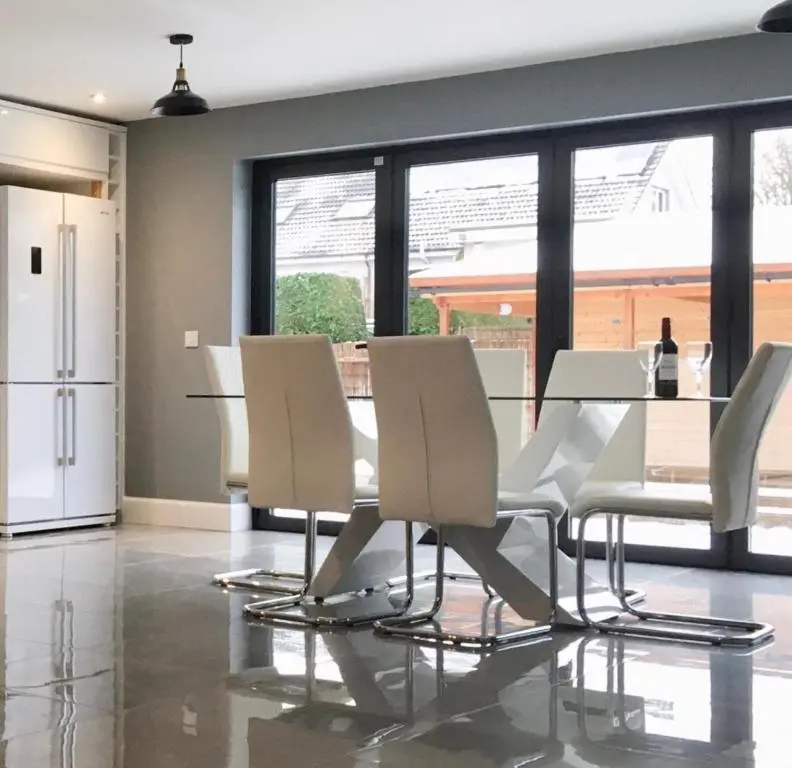 a dining room with a table and white chairs at Culduthel Cottage in Inverness