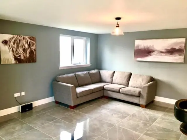 a living room with a couch and a window at Culduthel Cottage in Inverness