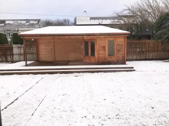 a small wooden building with a snow covered roof at Culduthel Cottage in Inverness