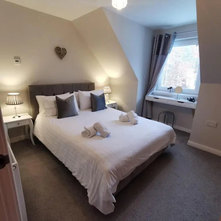 a bedroom with a large bed with two towels on it at Number 27 in Ullapool
