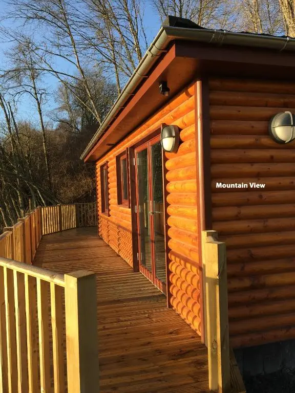 a wooden ramp leading to a cabin with a deck at Grantown Caravan Park in Grantown on Spey