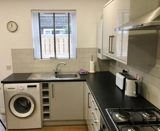 a kitchen with a sink and a washing machine at The Tack Room in Inverness