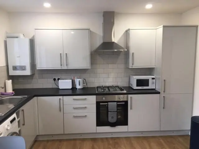 a kitchen with white cabinets and a stove and microwave at The Tack Room in Inverness