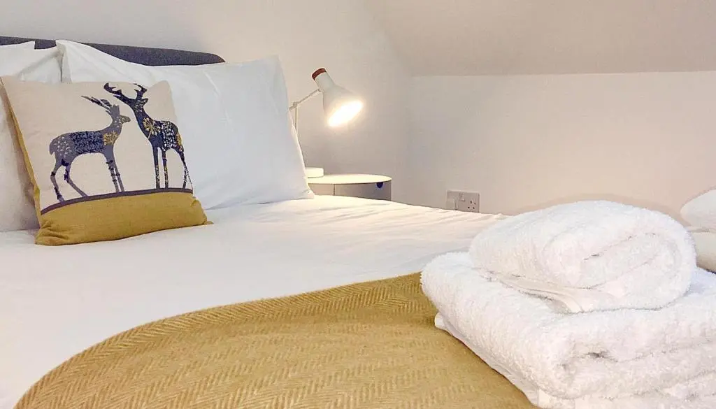 a bedroom with a bed with two giraffes on the pillow at The Tack Room in Inverness