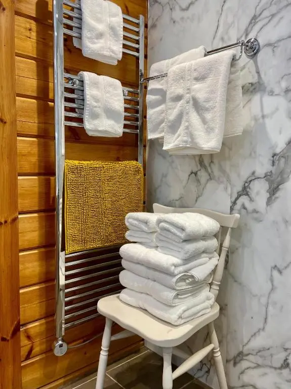 a pile of towels sitting on a chair in a bathroom at Deveron Valley Cottages in Marnoch