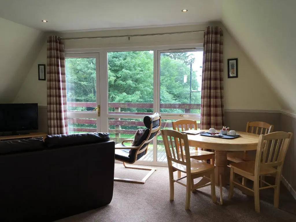 a living room with a table and chairs and a window at Thistle Lodge - Uk7051 in Glenurguhart