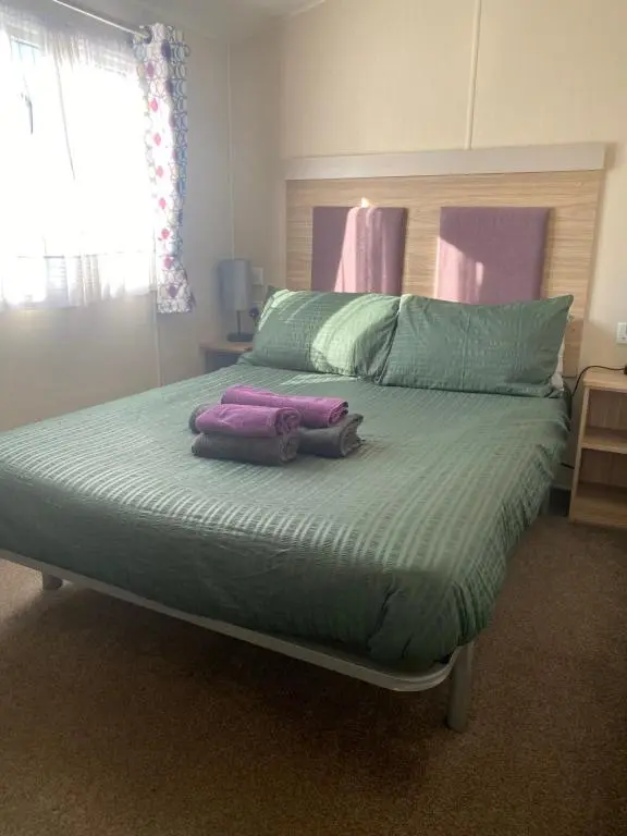 a bedroom with a large bed with two pillows on it at Paul\u2019s place silversands in Lossiemouth