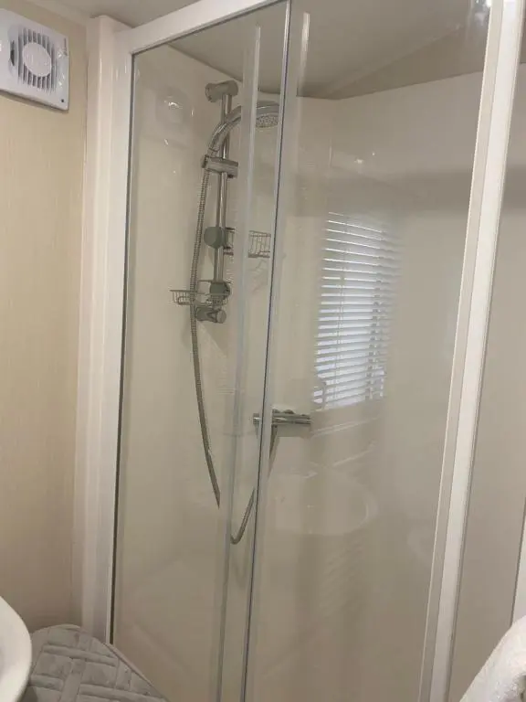 a shower with a glass door in a bathroom at Paul\u2019s place silversands in Lossiemouth