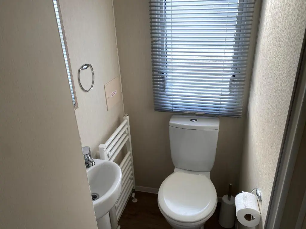 a small bathroom with a toilet and a sink at Paul\u2019s place silversands in Lossiemouth