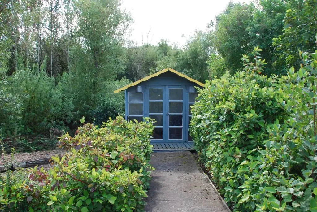 a blue doghouse in the middle of a garden at Unique Garden Centre Country Cottage in Fraserburgh