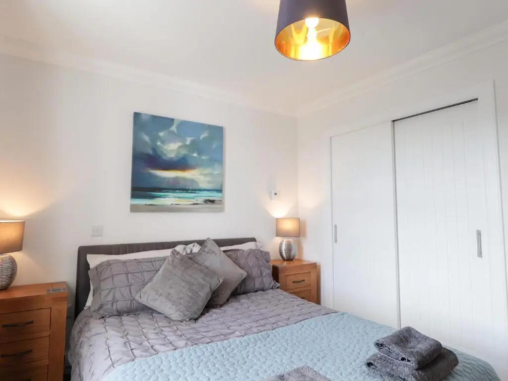 a bedroom with a bed and a painting on the wall at The Nook in Inverness