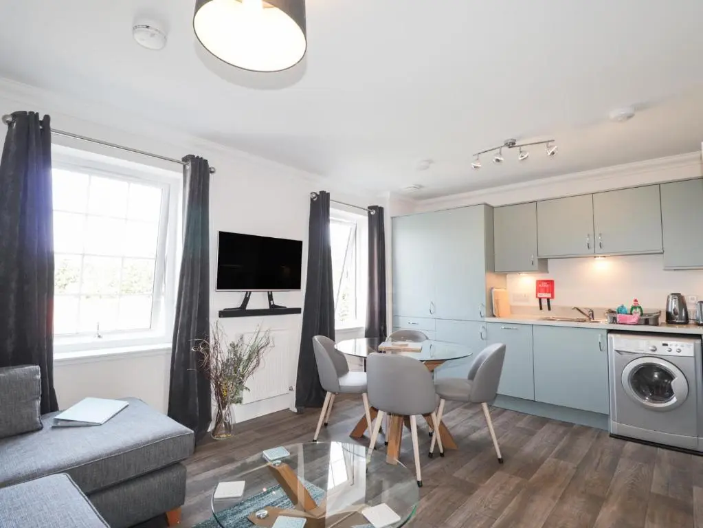 a kitchen and a living room with a table and chairs at The Nook in Inverness