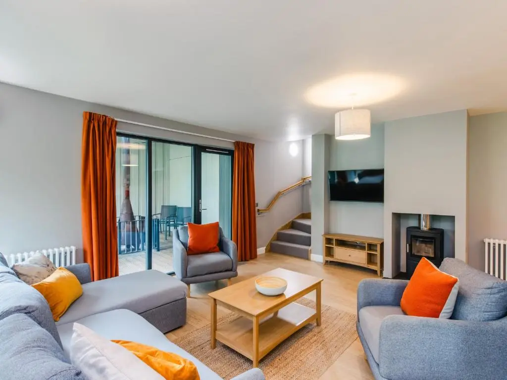 a living room with two couches and a fireplace at Red Deer Lodge in Kingussie