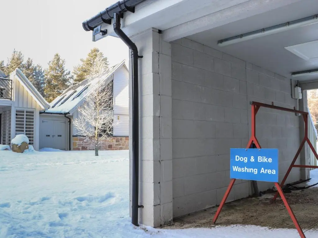 a sign on the side of a house in the snow at Red Deer Lodge in Kingussie