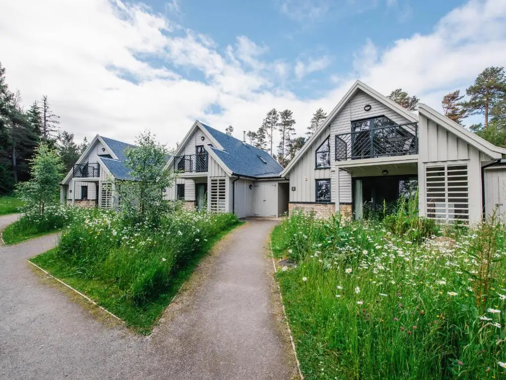 a large white house with a driveway at Wildcat Lodge in Kingussie