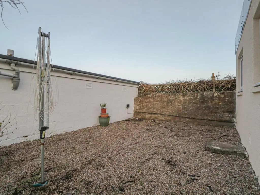 a courtyard of a building with a wall and a plant at The Neuk in Elgin